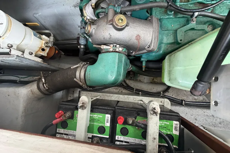 Slide: The Image of Engine compartment of a 2005 Camano Trawler with visible batteries and mechanical components. - 22