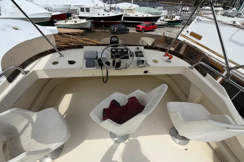 Slide: The Image of 2005 Camano Trawler helm with steering wheel, controls, and seating in a marina setting. - 24