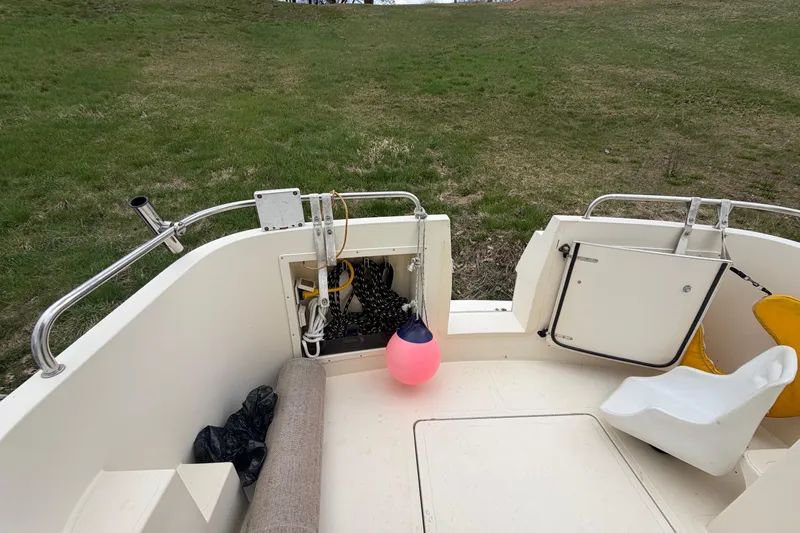 Slide: The Image of 2005 Camano Trawler boat deck with seating, storage, and a pink buoy. - 25