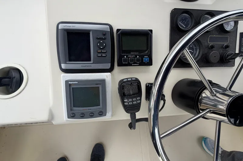 Slide: The Image of 2005 Camano Trawler helm with Garmin GPS, Raymarine depth finder, and steering wheel. - 27