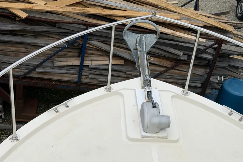 Slide: The Image of Bow of a 2005 Camano Trawler with anchor and railing, docked near wooden planks. - 29