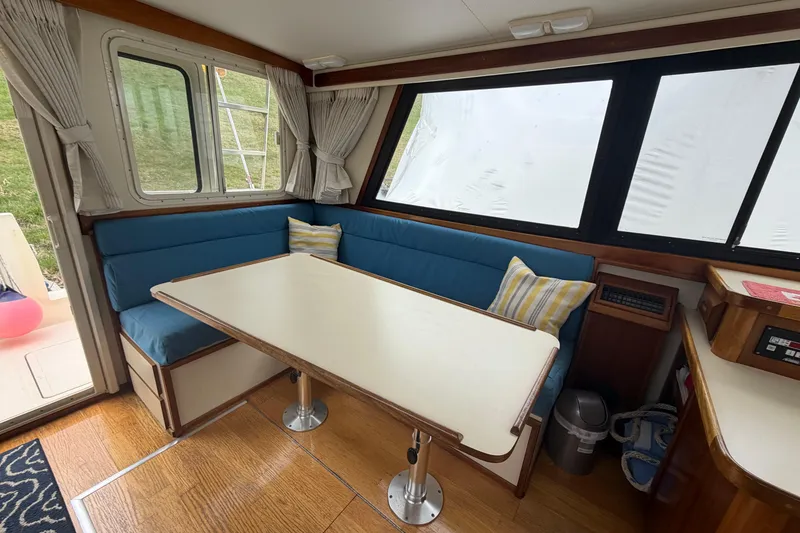 Slide: The Image of Interior of a 2005 Camano Trawler with a cozy dining area and blue seating. - 3