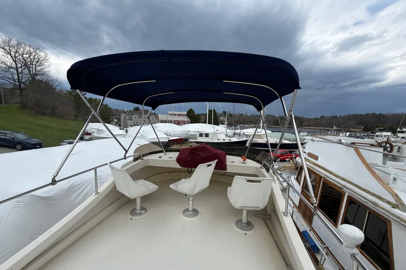 Slide: The Image of 2005 Camano Trawler boat deck with canopy, docked under cloudy skies. - 32
