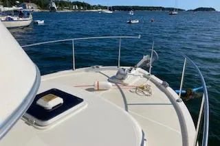 Slide: The Image of 2005 Camano Trawler on calm waters, featuring a spacious deck and scenic coastal view. - 34
