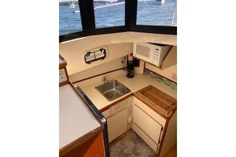 Slide: The Image of 2005 Camano Trawler kitchen with sink, microwave, and scenic window view. - 9