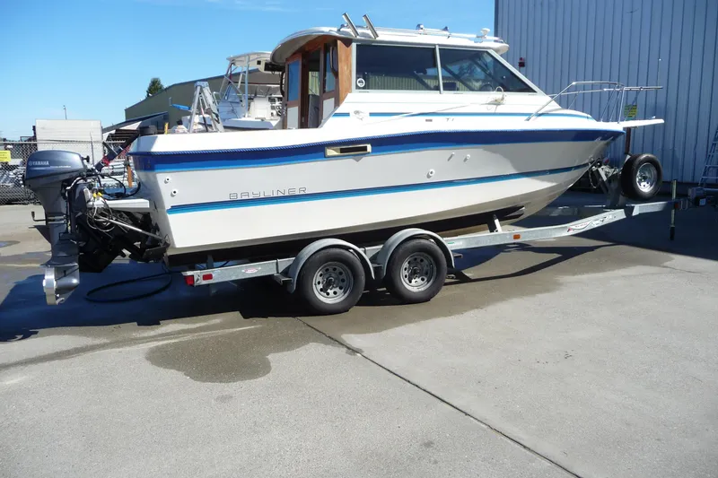 The Image of 1988 Bayliner 2102 Trophy boat on trailer, parked outdoors. - 0
