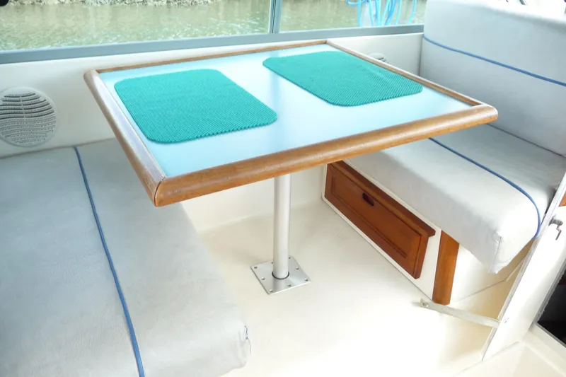 Slide: The Image of Interior of 1988 Bayliner 2102 Trophy boat with table and seating area. - 12