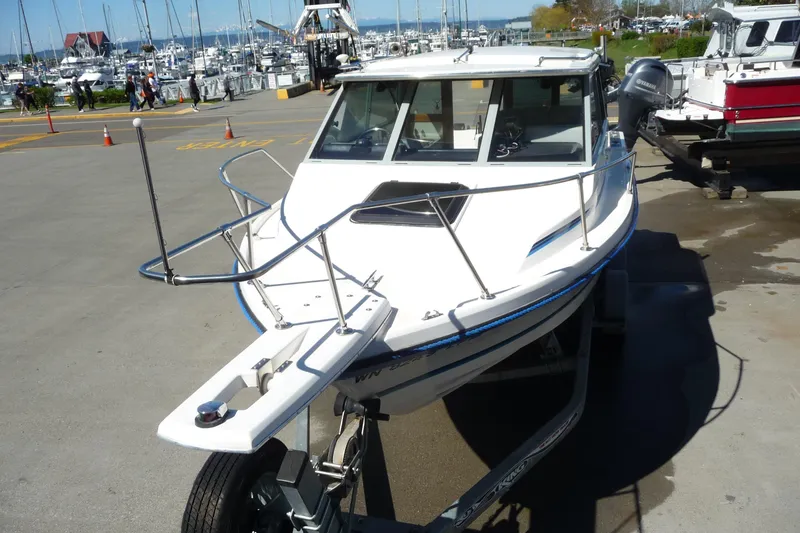 Slide: The Image of 1988 Bayliner 2102 Trophy boat on trailer at marina, surrounded by other boats. - 14