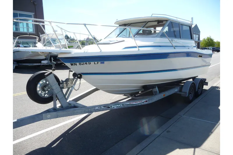 Slide: The Image of 1988 Bayliner 2102 Trophy boat on trailer, parked on street, sunny day. - 16