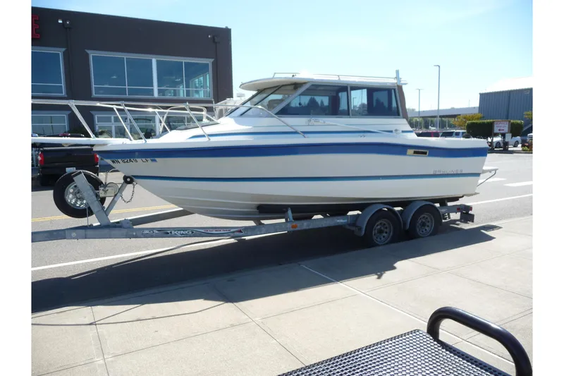 Slide: The Image of 1988 Bayliner 2102 Trophy boat on trailer, parked in urban setting. - 3