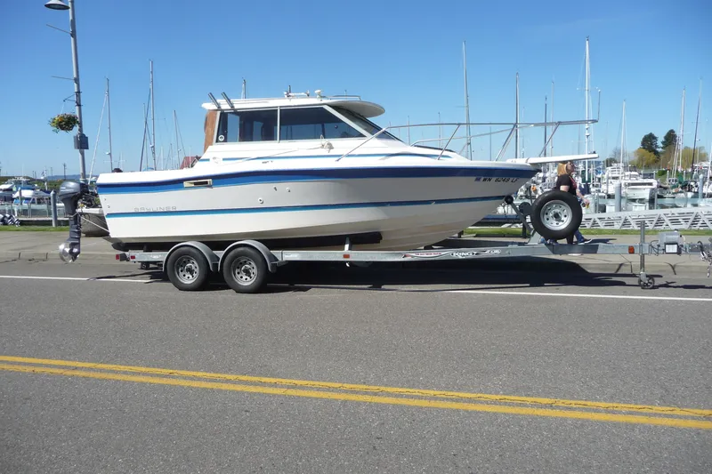 Slide: The Image of 1988 Bayliner 2102 Trophy boat on trailer at marina, clear sky background. - 4