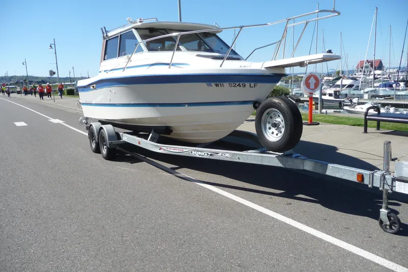 Slide: The Image of 1988 Bayliner 2102 Trophy boat on trailer near marina, sunny day. - 6