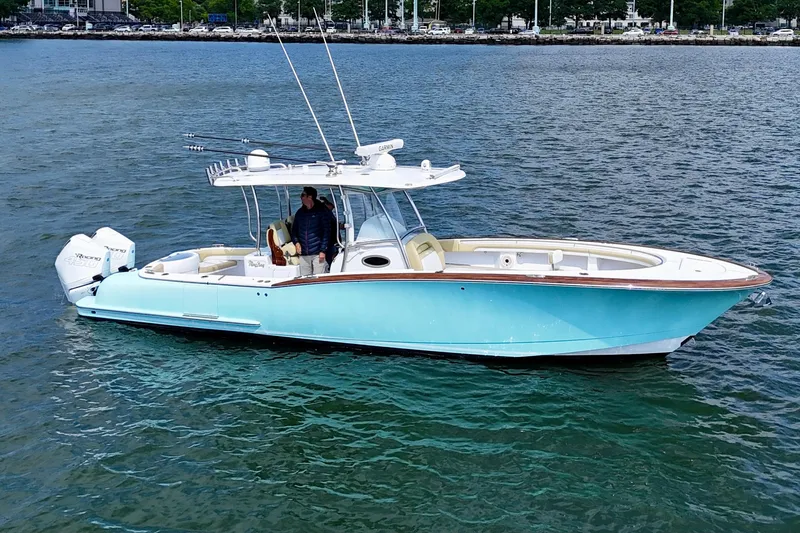 The Image of 2020 Mag Bay 33 CC boat on water, featuring sleek design and twin engines. - 0