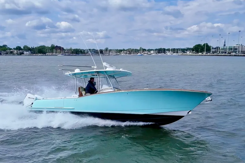 Slide: The Image of 2020 Mag Bay 33 CC boat cruising on water under a partly cloudy sky. - 1