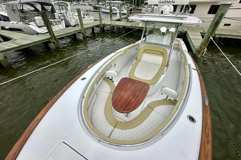 Slide: The Image of 2020 Mag Bay 33 CC boat with elegant seating and wooden table, docked at marina. - 10