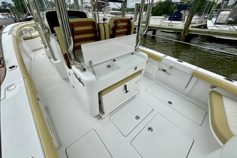 Slide: The Image of 2020 Mag Bay 33 CC boat interior with seating and storage, docked at marina. - 19