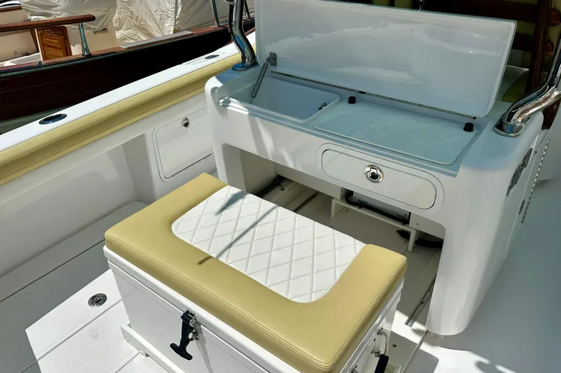 Slide: The Image of 2020 Mag Bay 33 CC boat interior with cushioned seating and storage area. - 20