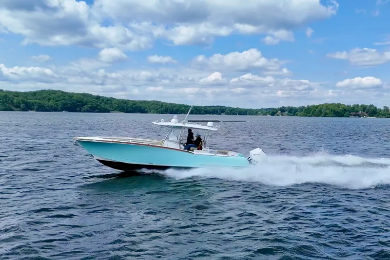 Slide: The Image of 2020 Mag Bay 33 CC cruising on a lake under a partly cloudy sky. - 3