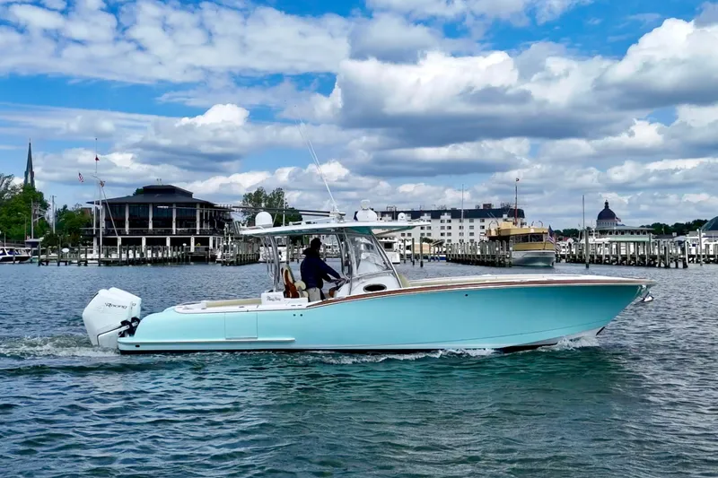 Slide: The Image of 2020 Mag Bay 33 CC boat cruising in a scenic harbor with cloudy sky. - 4