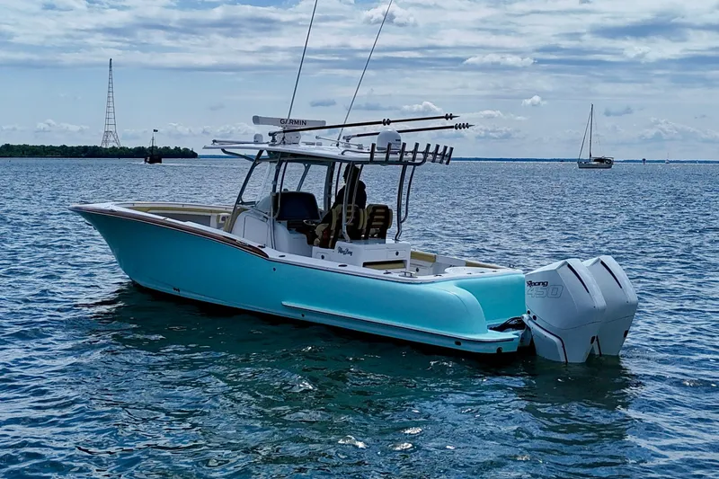 Slide: The Image of 2020 Mag Bay 33 CC boat on calm water, featuring twin engines and sleek design. - 8