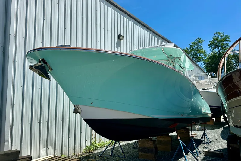 Slide: The Image of 2020 Mag Bay 33 CC boat in storage, turquoise hull, outdoor setting. - 9