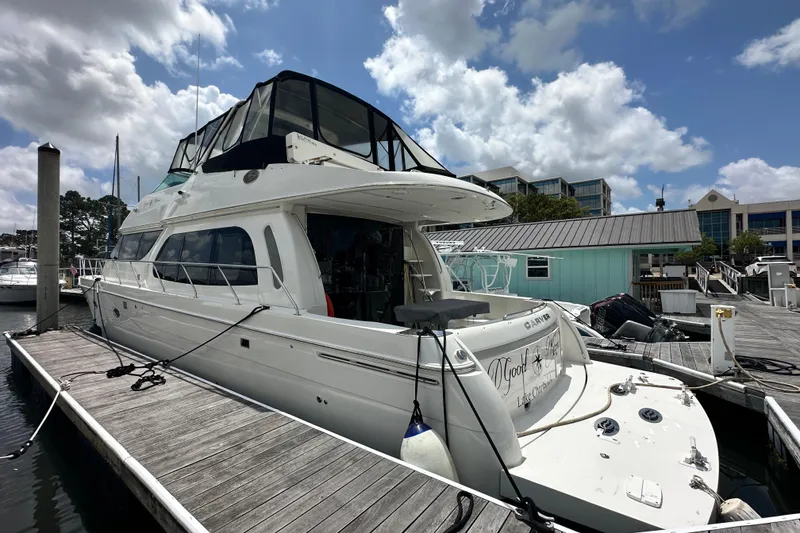 The Image of 2006 Carver 56 Voyager yacht docked at marina under partly cloudy sky. - 0