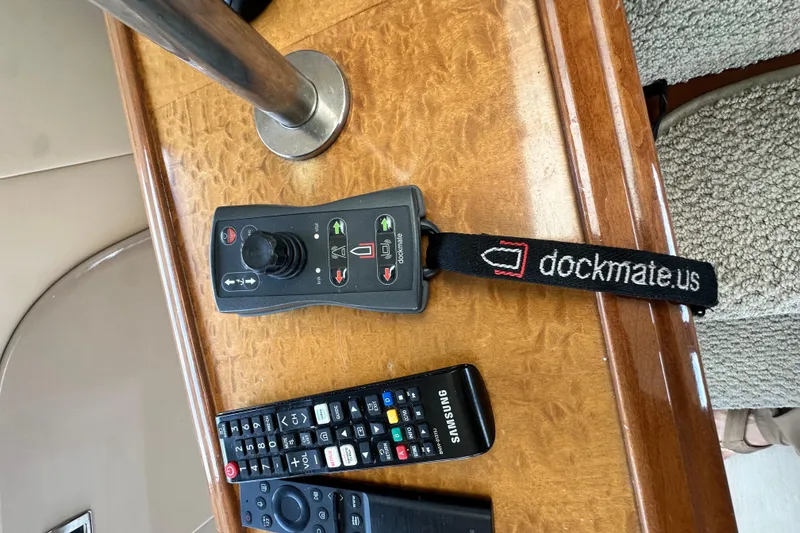 Slide: The Image of Remote controls on a wooden surface in a 2006 Carver 56 Voyager yacht. - 16