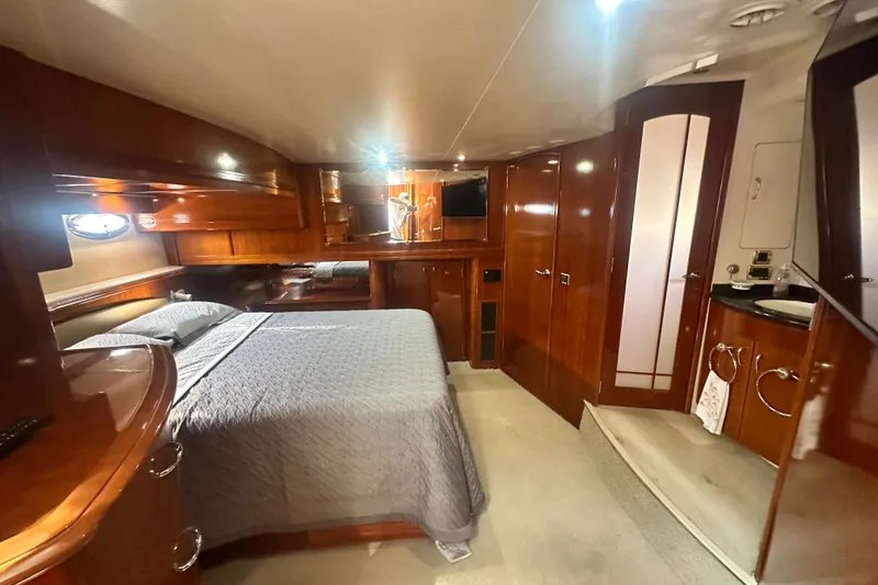 Slide: The Image of Luxurious 2006 Carver 56 Voyager yacht bedroom with elegant wood finishes and modern amenities. - 17