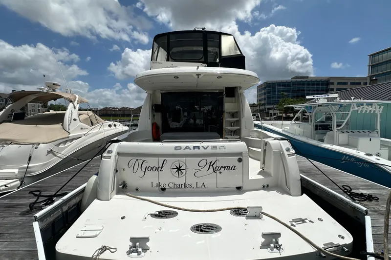 Slide: The Image of 2006 Carver 56 Voyager yacht docked, "Good Karma," Lake Charles, LA, under a partly cloudy sky. - 2