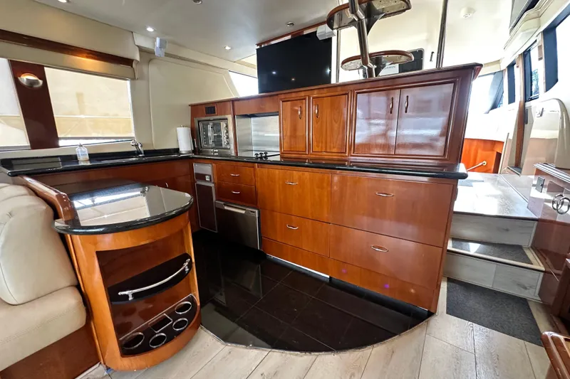 Slide: The Image of Luxurious 2006 Carver 56 Voyager yacht interior with elegant wood cabinetry and modern kitchen amenities. - 8
