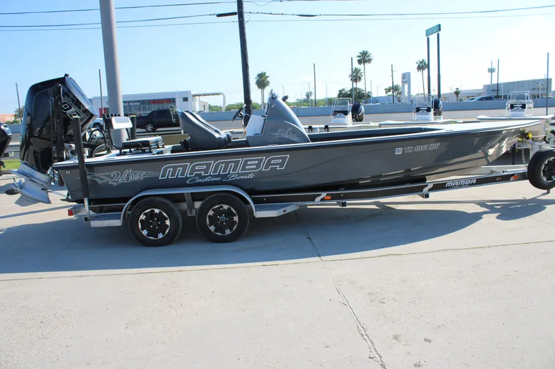 Slide: The Image of 2023 Mamba 24VX boat on trailer, sleek design, parked outdoors. - 1