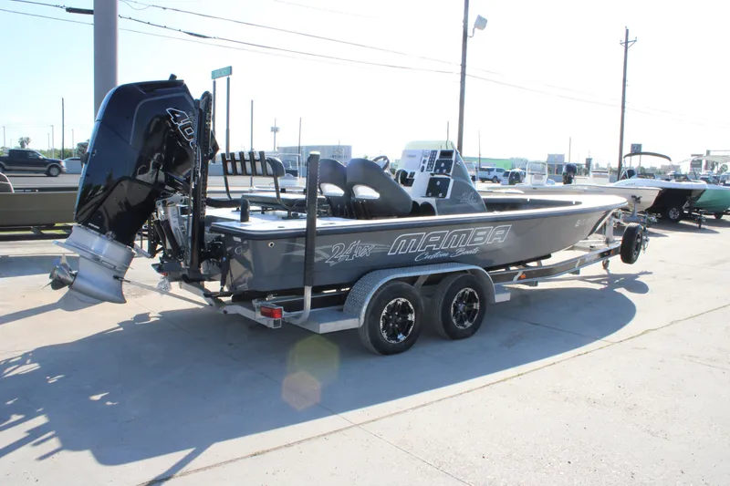 Slide: The Image of 2023 Mamba 24VX boat on trailer, featuring powerful outboard motor, parked outdoors. - 7