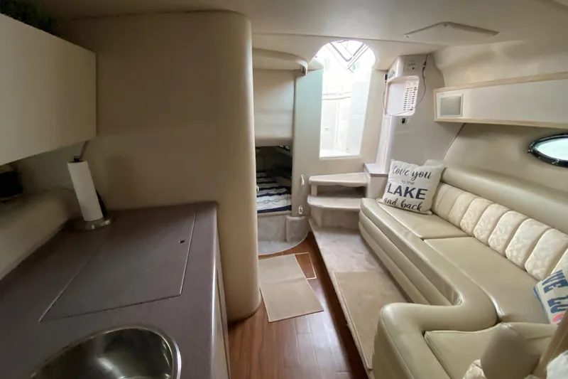 Slide: The Image of Interior of a 1995 Regal Commodore 322 yacht with beige seating and cozy decor. - 24