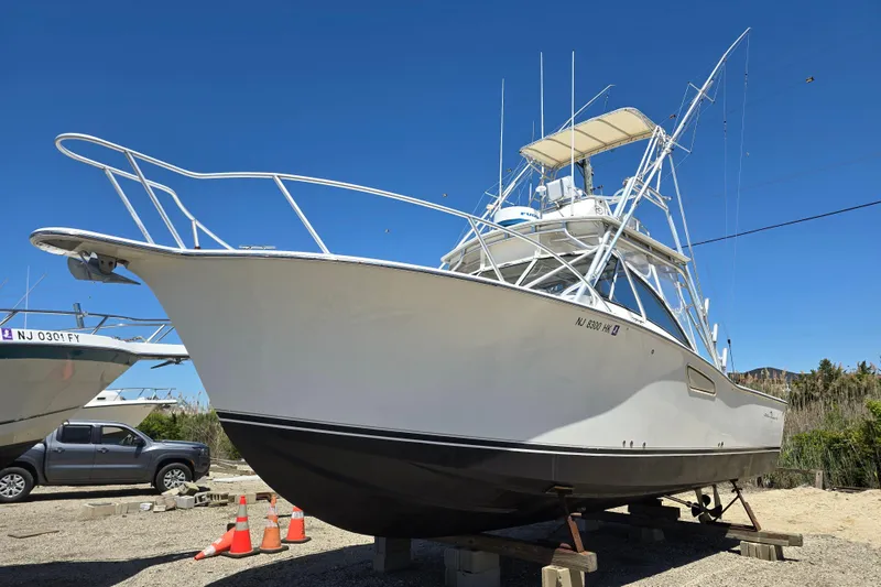 The Image of 2003 Albemarle 305 Express Fisherman boat on dry dock under clear blue sky. - 0