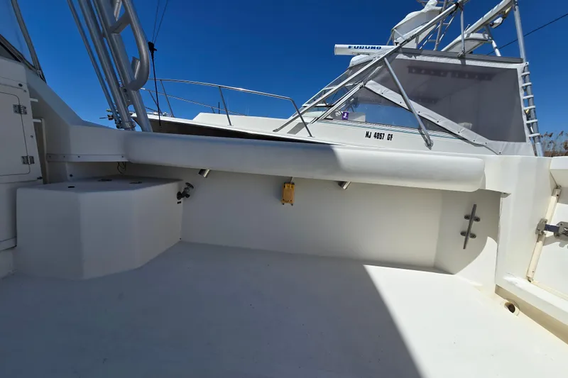 Slide: The Image of 2003 Albemarle 305 Express Fisherman boat deck with seating and storage, under clear blue sky. - 11