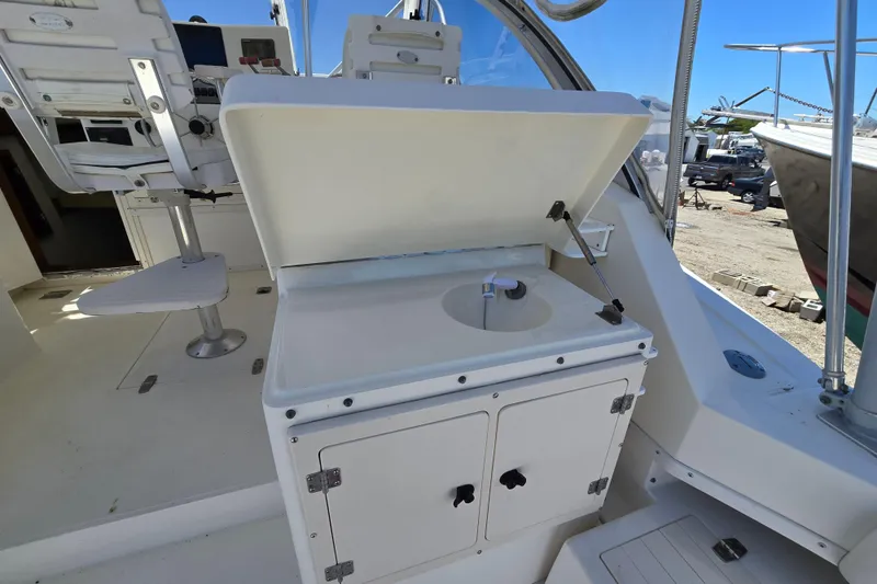 Slide: The Image of 2003 Albemarle 305 Express Fisherman boat interior with open storage compartment and seating. - 12
