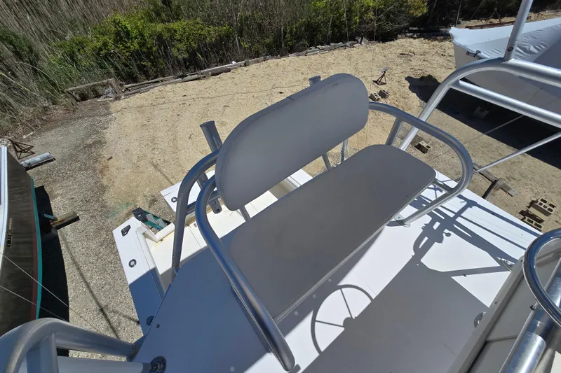 Slide: The Image of 2003 Albemarle 305 Express Fisherman boat seat with metal railing, docked on sandy terrain. - 17