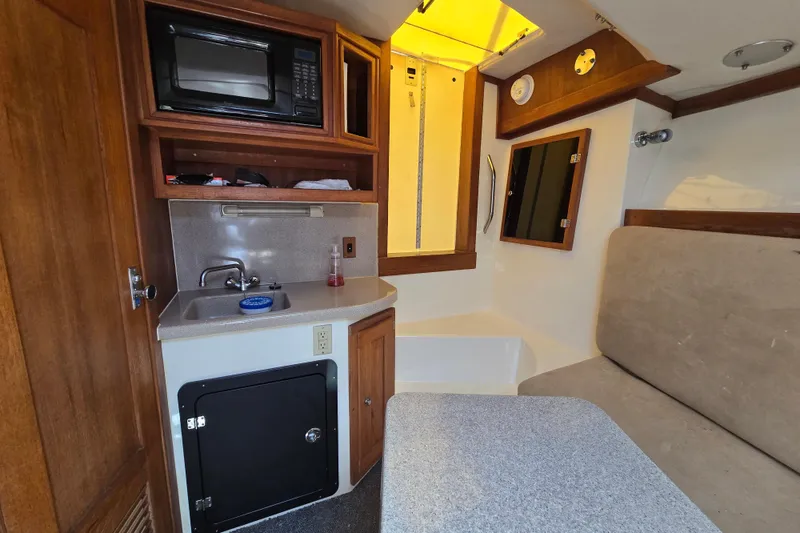 Slide: The Image of Interior of 2003 Albemarle 305 Express Fisherman boat with kitchenette and seating area. - 22