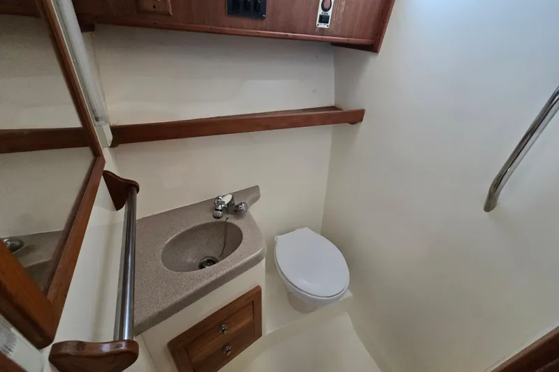 Slide: The Image of 2003 Albemarle 305 Express Fisherman boat bathroom with sink, toilet, and wooden cabinetry. - 24