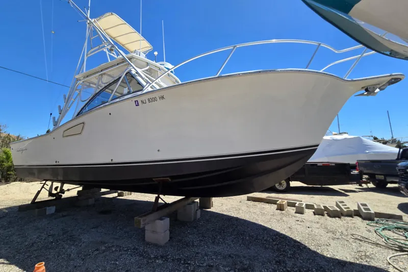 Slide: The Image of 2003 Albemarle 305 Express Fisherman boat on dry dock under clear blue sky. - 3