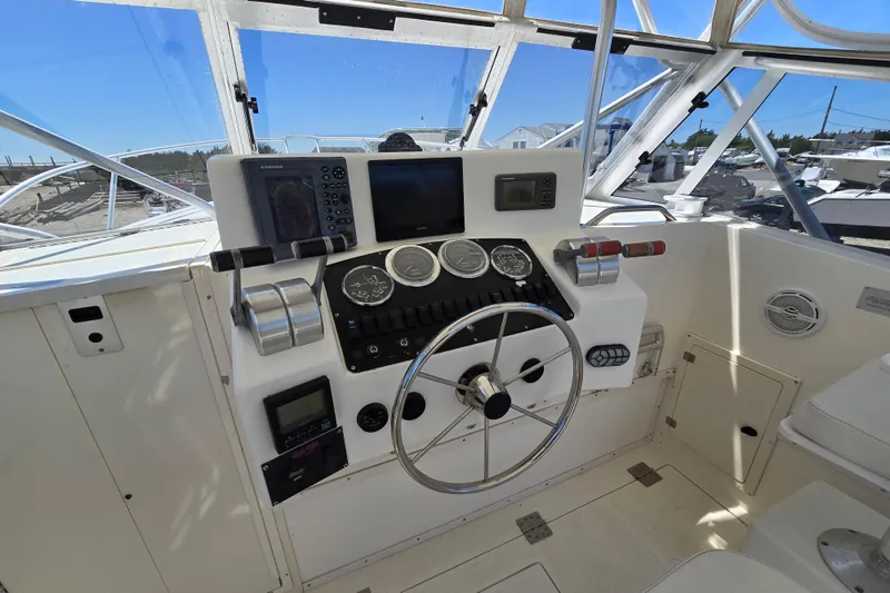 Slide: The Image of 2003 Albemarle 305 Express Fisherman helm with steering wheel, gauges, and navigation equipment. - 4