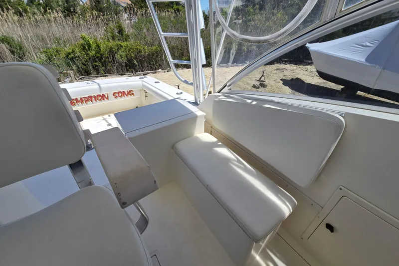 Slide: The Image of 2003 Albemarle 305 Express Fisherman boat interior with seating and ladder, docked outdoors. - 9