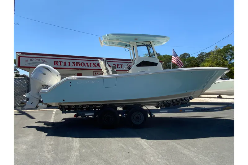 The Image of 2026 Cobia 245 Center Console boat on trailer at dealership. - 1