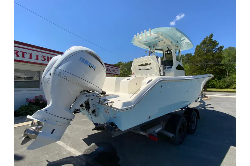 Slide: The Image of 2026 Cobia 245 Center Console boat with Yamaha engine, parked on a trailer under clear blue sky. - 10
