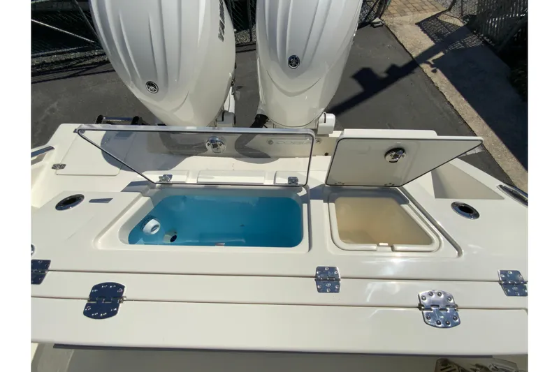 Slide: The Image of 2026 Cobia 245 Center Console boat with open storage compartments and dual engines. - 15