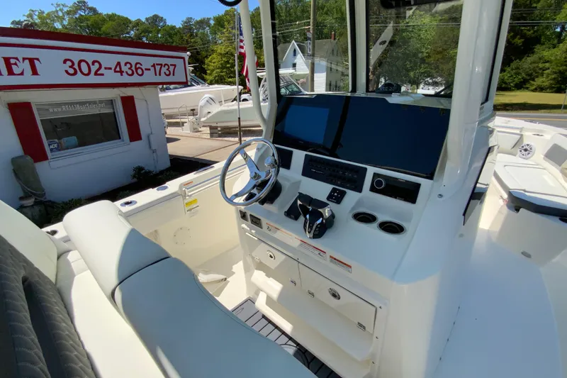 Slide: The Image of 2026 Cobia 245 Center Console boat interior with steering wheel and control panel. - 18