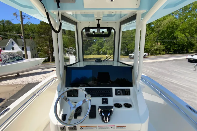 Slide: The Image of 2026 Cobia 245 Center Console boat dashboard with steering wheel and controls. - 19