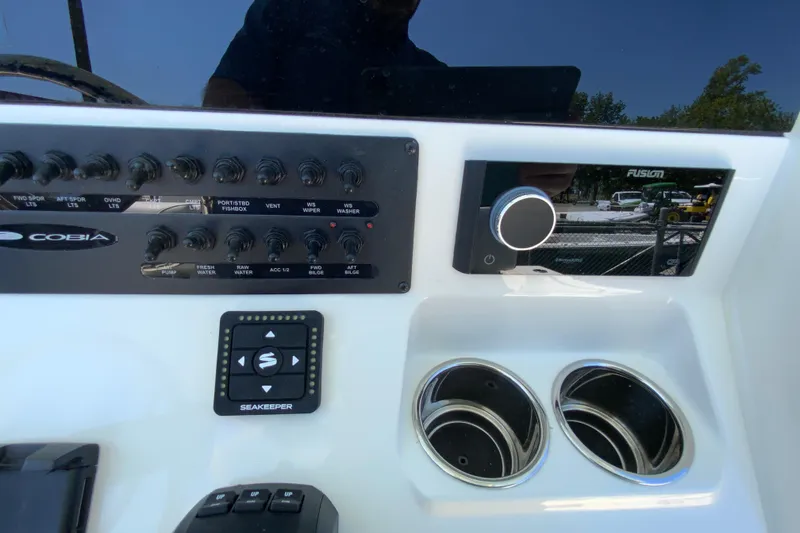 Slide: The Image of 2026 Cobia 245 Center Console dashboard with controls, Seakeeper system, and Fusion audio panel. - 21