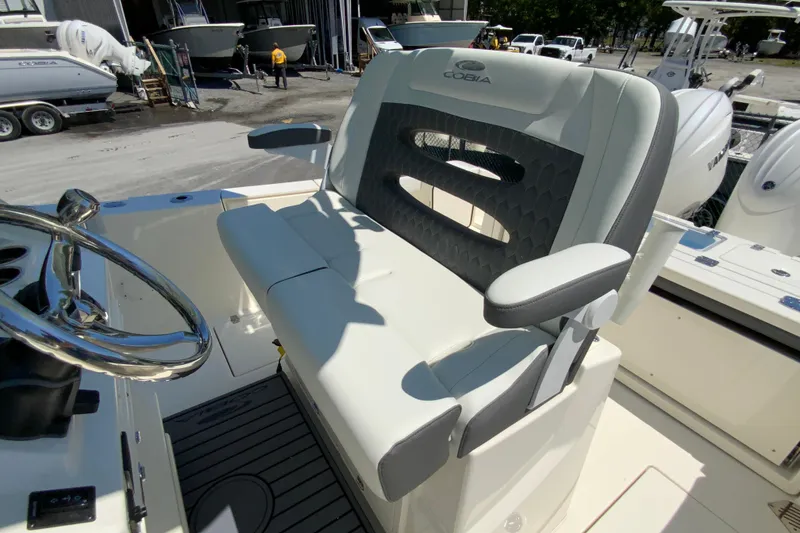 Slide: The Image of 2026 Cobia 245 Center Console boat interior with steering wheel and cushioned seating. - 25