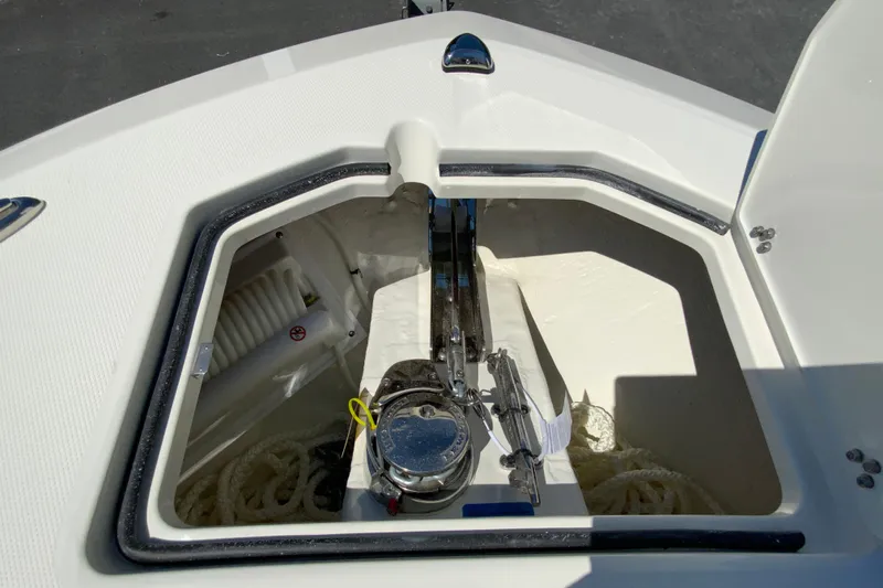 Slide: The Image of 2026 Cobia 245 Center Console anchor locker with rope and winch system. - 32